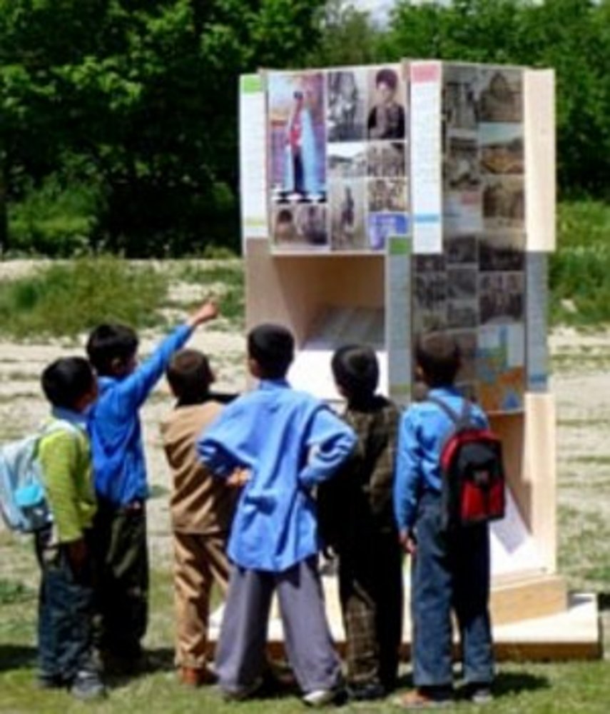 Afghanische Schulkinder vor einem Turm des Wissens