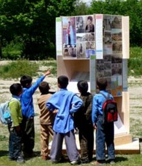 Afghanische Schulkinder vor einem Turm des Wissens 